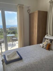 a bedroom with a bed with a view of a balcony at Captains View in Kefallonia
