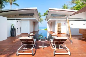 a deck with chairs and a table on a house at Iniala Beach House in Natai Beach