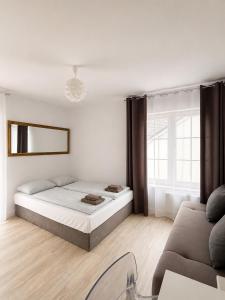 a white bedroom with a bed and a couch at Twój Port in Krynica Morska +56 photos