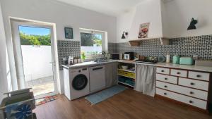 a kitchen with a sink and a washing machine at Alentejo Colours Cano in Cano