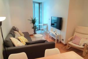 a living room with a couch and a tv at Apartamento Playa Foz in Foz