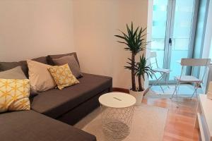 a living room with a couch and a table at Apartamento Playa Foz in Foz