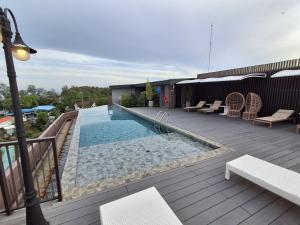 a deck with a swimming pool on a building at Rawai Sea Escape 1BR With Rooftop Pool in Rawai Beach