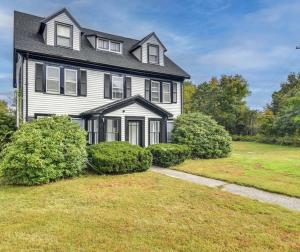 a large black and white house with a yard at Charming Condo near Gillette Stadium in Sharon