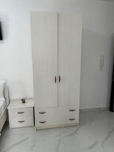 a white cabinet in a bedroom with a table at Radhima Sun Studio in Vlorë