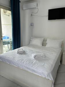 a white bed with two towels on top of it at Radhima Sun Studio in Vlorë