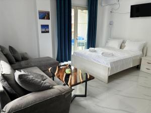a living room with a bed and a couch at Radhima Sun Studio in Vlorë