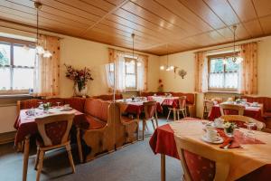 a dining room with tables and chairs and windows at Gäste-Haus Rösch in Wiesent