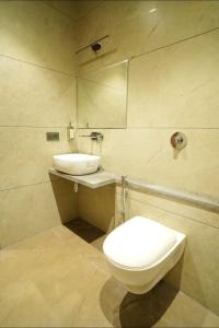 a bathroom with a toilet and a sink at hotel manjushree in Pachmarhī +18 photos