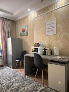 a kitchen with a desk with a microwave and a refrigerator at Hôtel Baldei in Chişinău