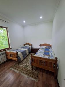 a bedroom with two beds and a window at Green Paradise in Qax