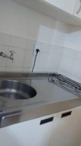 a kitchen counter with a sink and a faucet at Uniflat Hotel Bauru in Bauru