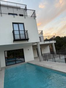 a house with a swimming pool in front of a building at Casa la Perla Solo adultos in Béznar
