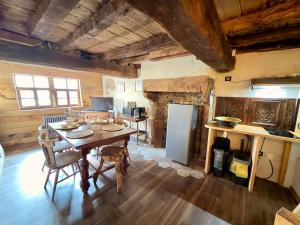 a kitchen and dining room with a table and refrigerator at Le Logis du Martray, maison historique in Lamballe Armor