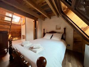 a bedroom with a large bed with towels on it at Le Logis du Martray, maison historique in Lamballe Armor