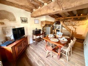 a dining room with a table and a television at Le Logis du Martray, maison historique in Lamballe Armor