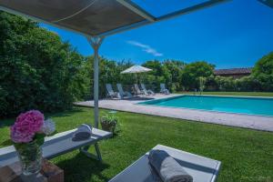 a yard with a pool and a table with a vase of flowers at Preseglie Lake Garda in Desenzano del Garda