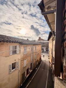a view of a street from an alley between two buildings at La Terrazza sul Lago in Panicale +13 photos