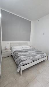 a bed in a room with a white wall at La Casa nella Rocca in Roccagloriosa