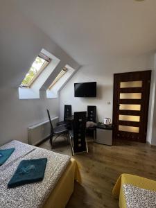 a room with two beds and a table and a television at ahoj PRZYLESIE in Pobierowo