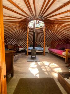 a room in a yurt with beds and a lamp at Oakdean Cottage Yurt in Blakeney