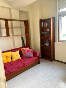 a red couch with colorful pillows in a room at Sol e Praia in Figueira da Foz
