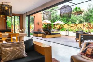 a living room with furniture and a large window at Villa Madjha Ecolodge Marrakech in Marrakesh