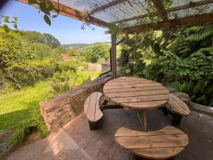 a wooden table and bench sitting on a patio at Oakdean Cottage Yurt in Blakeney