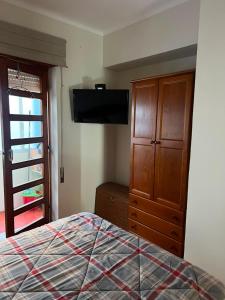 a bedroom with a bed and a flat screen tv at Sol e Praia in Figueira da Foz