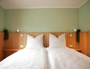 two beds sitting next to each other in a room at Hafen Bungalow in Kirchdorf