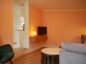 a living room with a couch and a tv at Hafen Bungalow in Kirchdorf