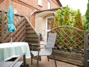a table and chairs and an umbrella on a patio at Hafen Bungalow in Kirchdorf