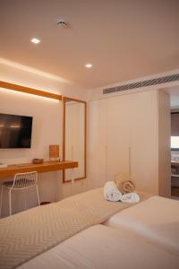 zwei Betten in einem Zimmer mit Schreibtisch und Fernseher in der Unterkunft Ynaira hotel & Spa in Ariany