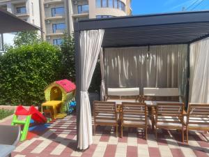 a gazebo with chairs and a table and a playground at Pensiunea Orion in Costinesti