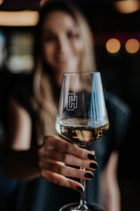 a woman holding up a glass of wine at Christians Weinblick in Mehrnbach