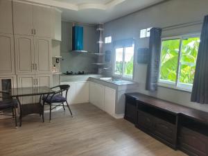 a kitchen with a table and chairs and a window at Hua hin pool view in Hua Hin