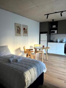 ein Schlafzimmer mit Bett und Tisch und eine Küche in der Unterkunft Live Smart in Montevideo