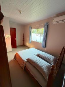 a bedroom with a large bed with a window at Casa completa 3 quartos in Sinop