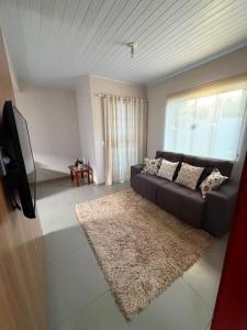 a living room with a couch and a rug at Casa completa 3 quartos in Sinop