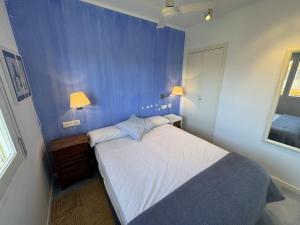 a bedroom with a bed with a blue wall at Mare Nostrum 143 in Torroella de Montgrí
