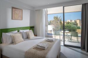 a bedroom with a large bed and a balcony at Meramaglia Hotel in Malia