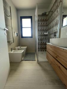 a bathroom with a sink and a tub and a toilet at La Romantica in Riccione