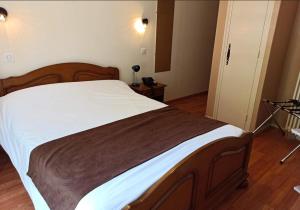 a bedroom with a large bed with white sheets at Logis Hotel Restaurant La Chaumière in Tournon-sur-Rhône +13 photos