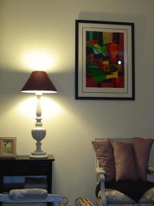 een lamp in een woonkamer met een bank en een foto bij La Sabotiere in Pluméliau