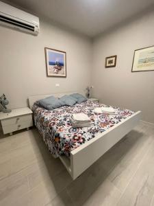 a bedroom with a bed with a comforter on it at La Romantica in Riccione