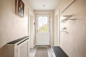 a hallway with a white door and a window at Reethus Nordstil in Borgsum