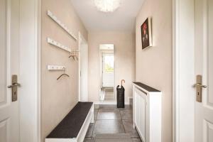 a hallway of a home with a stairwell with a bench at Reethus Nordstil in Borgsum