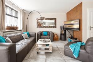 a living room with a couch and a table at Reethus Nordstil in Borgsum
