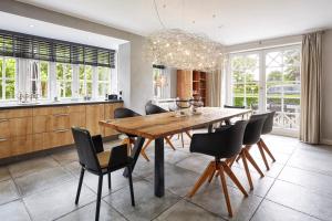 a dining room with a wooden table and chairs at Reethus Nordstil in Borgsum