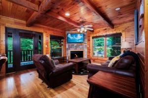 a living room with leather furniture and a fireplace at Evening Star in Gatlinburg